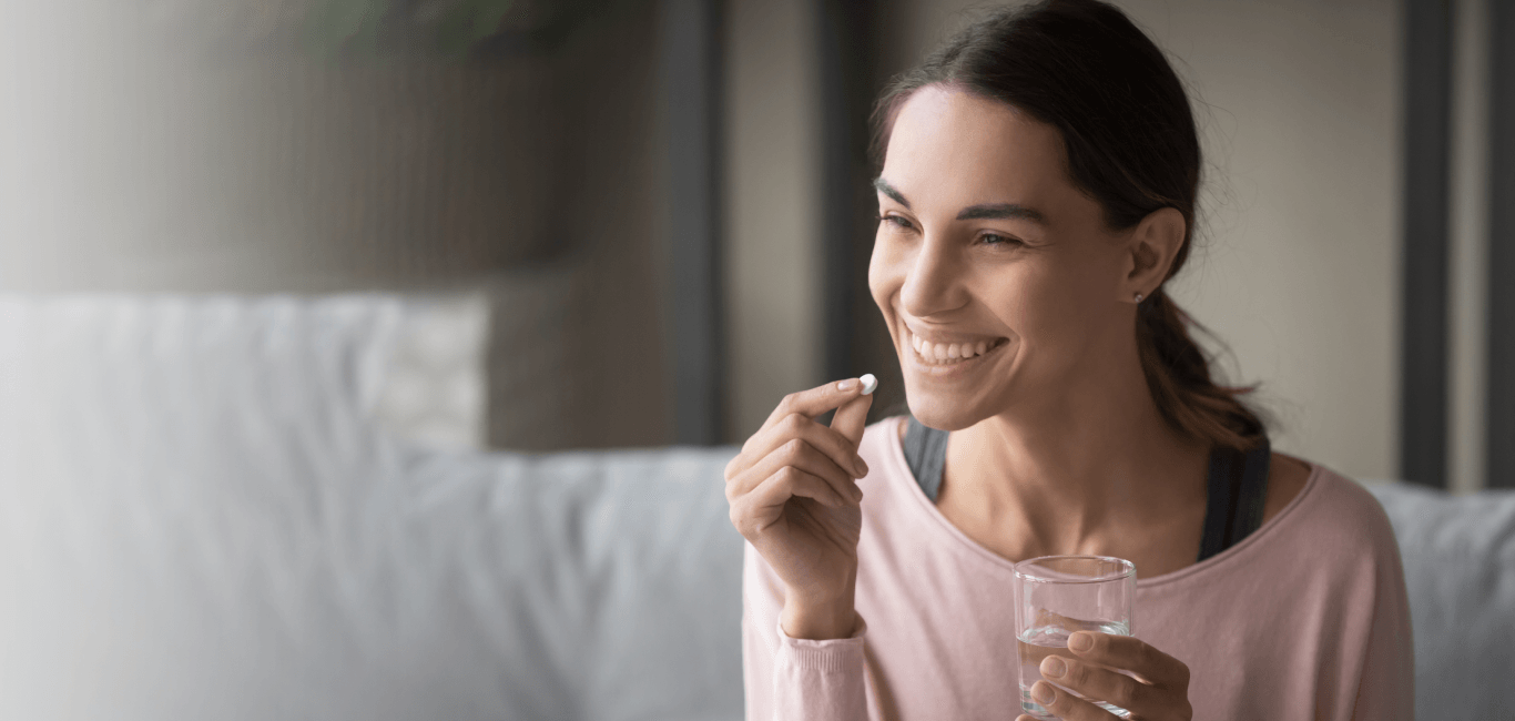 Una cápsula de suplemento tomada con un vaso de agua.